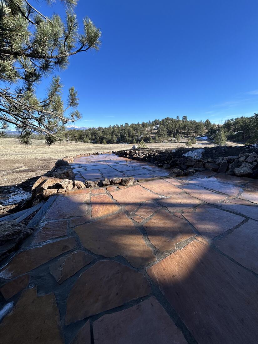Flagstone patio with boulder border and sweeping Colorado mountain views