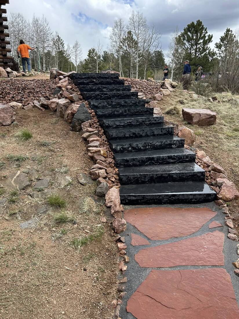 Natural stone slab staircase set into a boulder-lined hillside