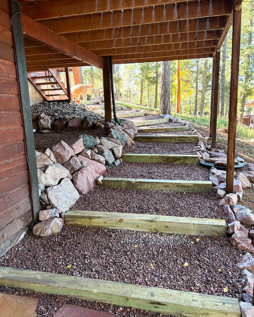 Timber steps with gravel tread infill and boulder border under a deck